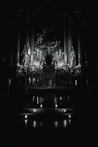 A serene altar with candles and San Simón statues glowing softly in candlelight.