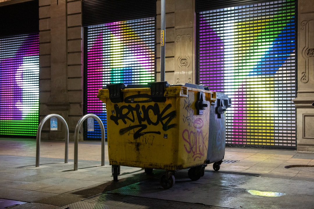a yellow garbage can with graffiti on it