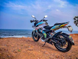 Sunset view of rugged coastline with motorcycle parked on cliff edge.