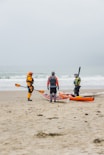 a group of people with kayaks on a beach