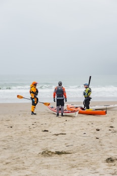 a group of people with kayaks on a beach