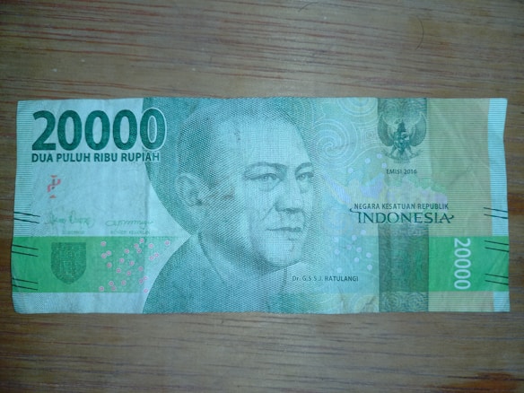 A 20000 Indonesian Rupiah banknote with a portrait of a historical figure on the right side. The note features intricate patterns and security details, along with text indicating its denomination and the country of origin.
