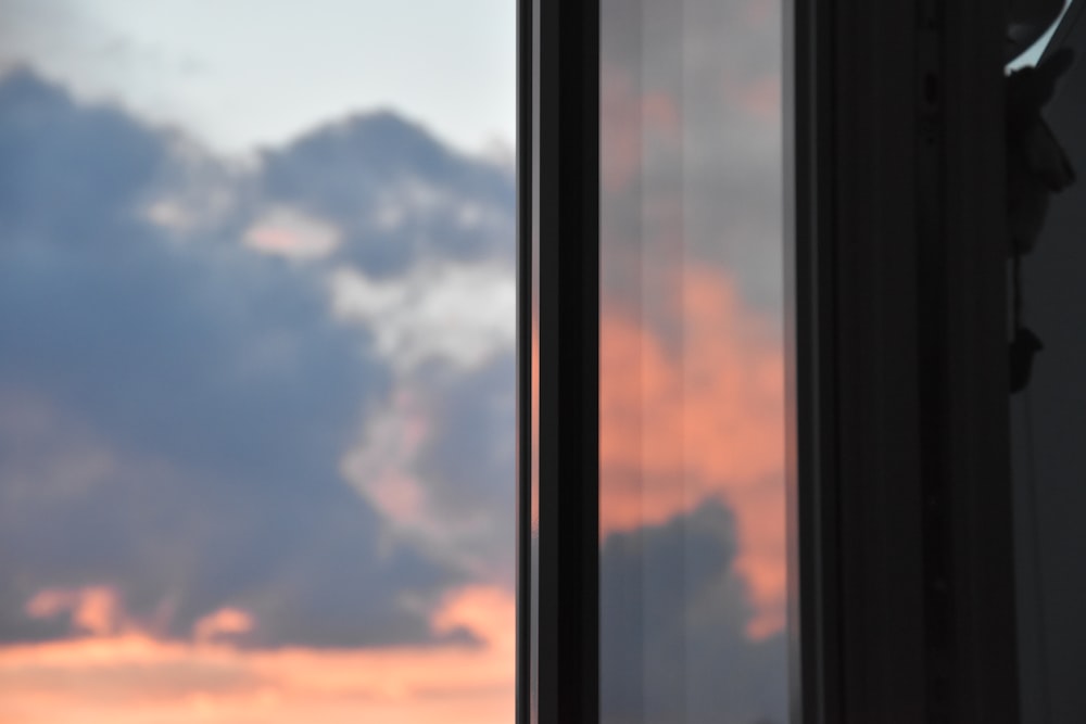 a window with a sunset in the background