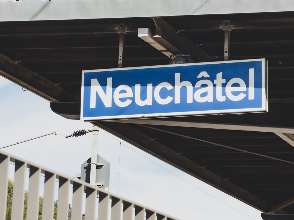 a blue sign on a bridge