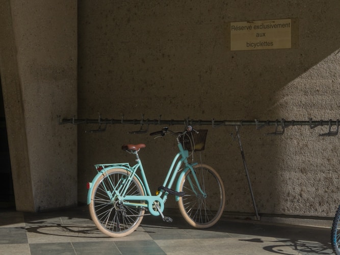 Türkisfarbenes Citybike an einer Wand mit Velohaken