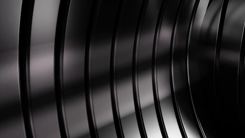 Close-up of matte black metallic textures reflecting subtle silver highlights.