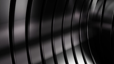 Golden light reflecting off a deep black matte finish on a luxury vehicle’s curved surface