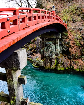 a red bridge over a river