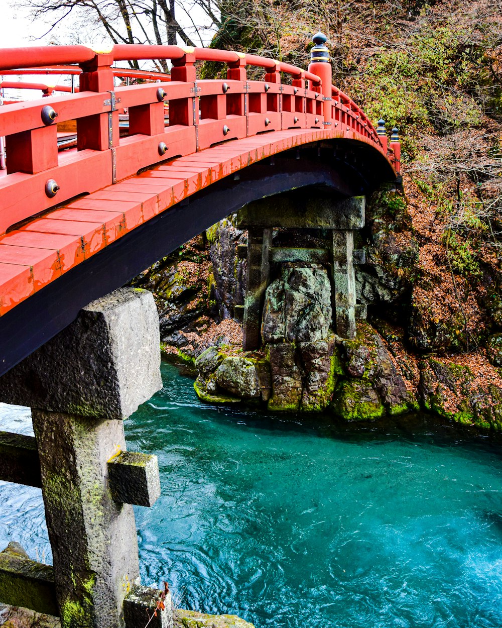 a red bridge over a river