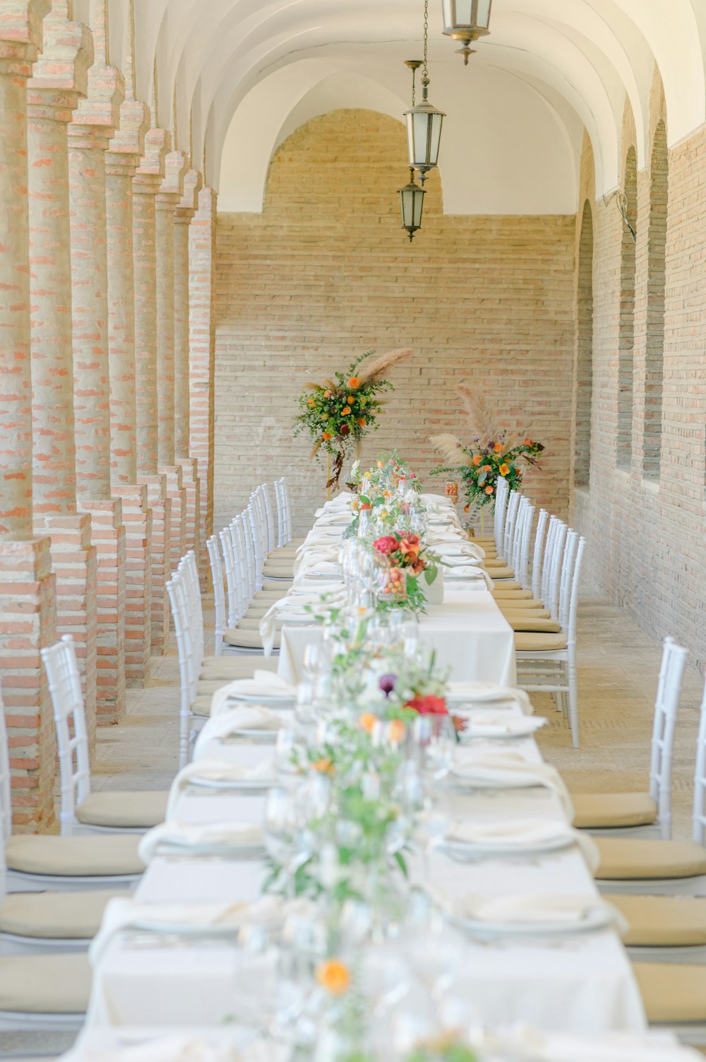 una grande sala da pranzo con una grande tavola apparecchiata con fiori