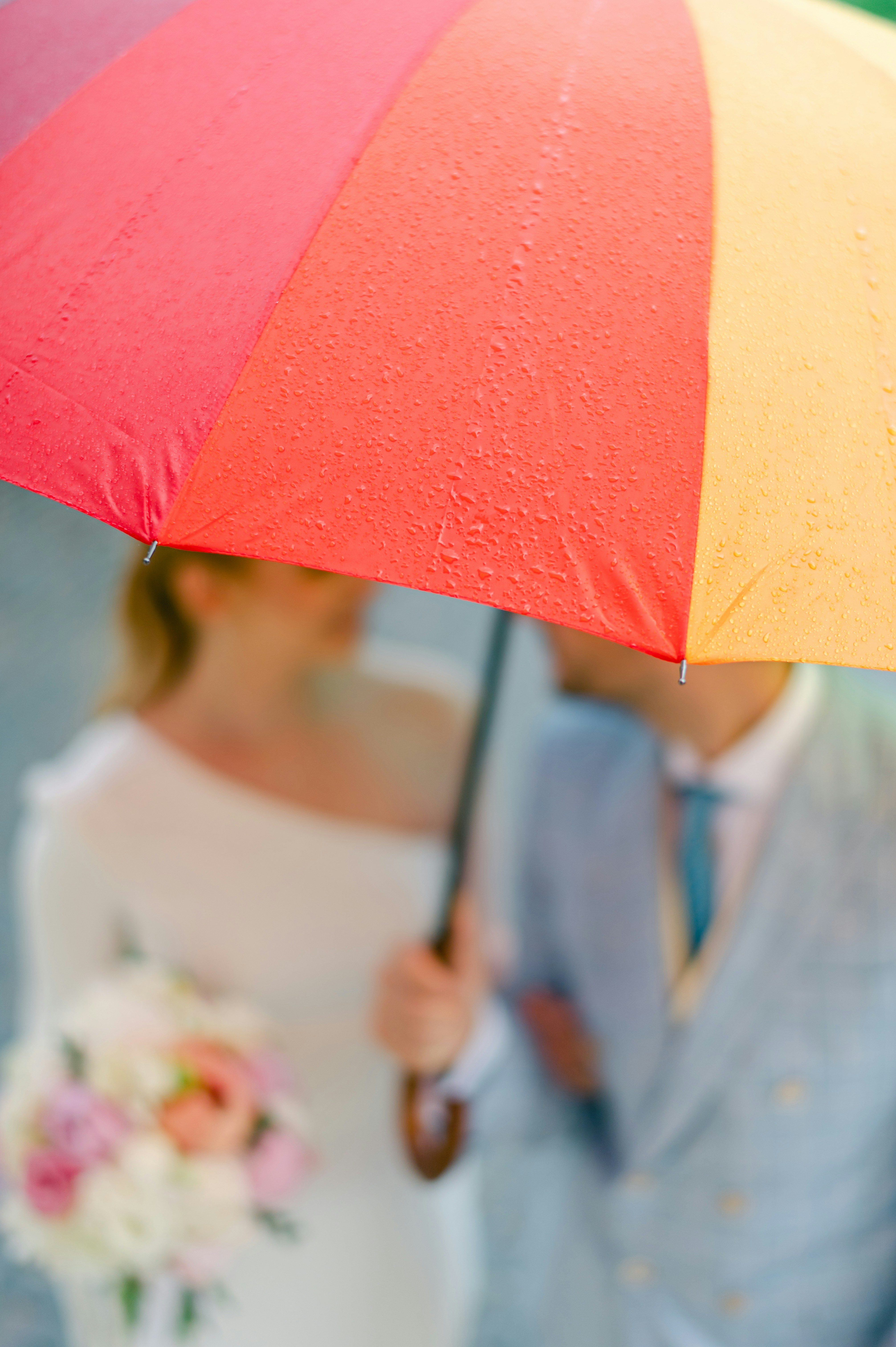 a couple of people walk under an umbrella