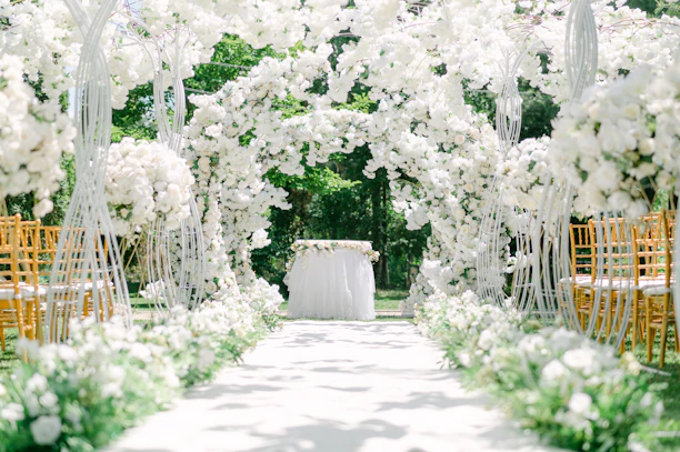 A pristine bridal white turf aisle lined with delicate floral arrangements under a sunny Florida sky.