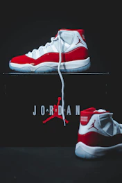 Pair of Jordan 1 sneakers displayed on a sleek black surface highlighting details