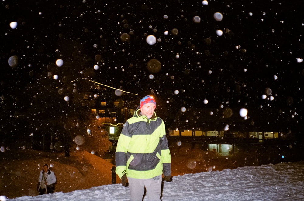 a man in a yellow jacket holding a ski pole