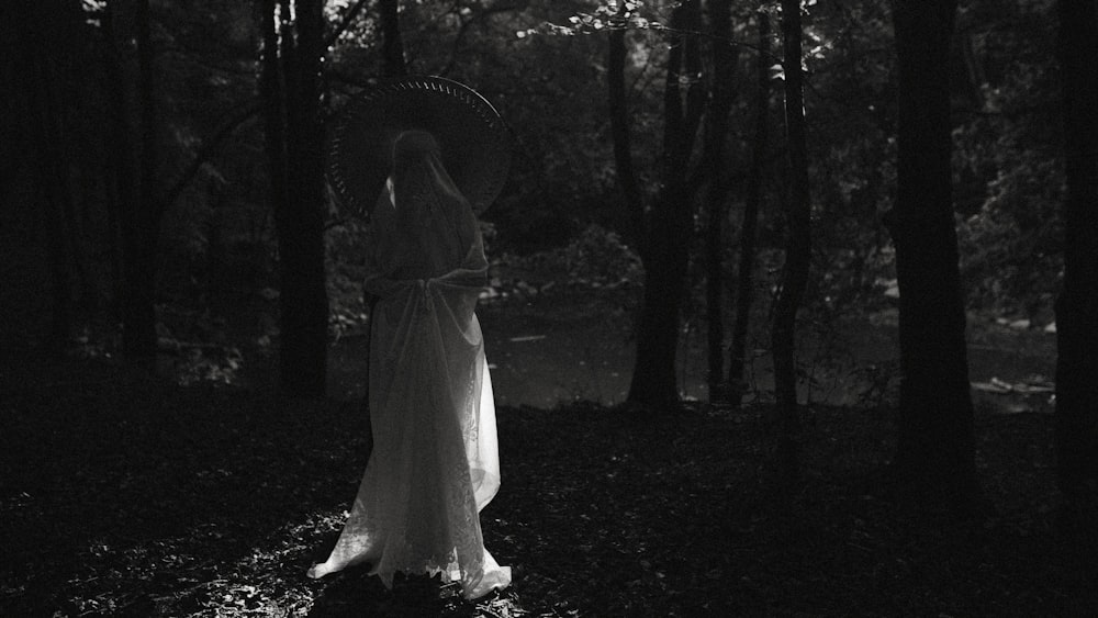 a person in a dress with an umbrella in a forest