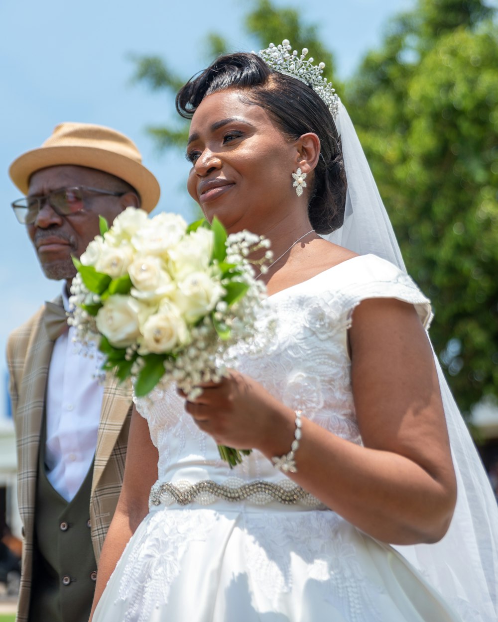 a woman in a white dress holding a bouquet of flowers