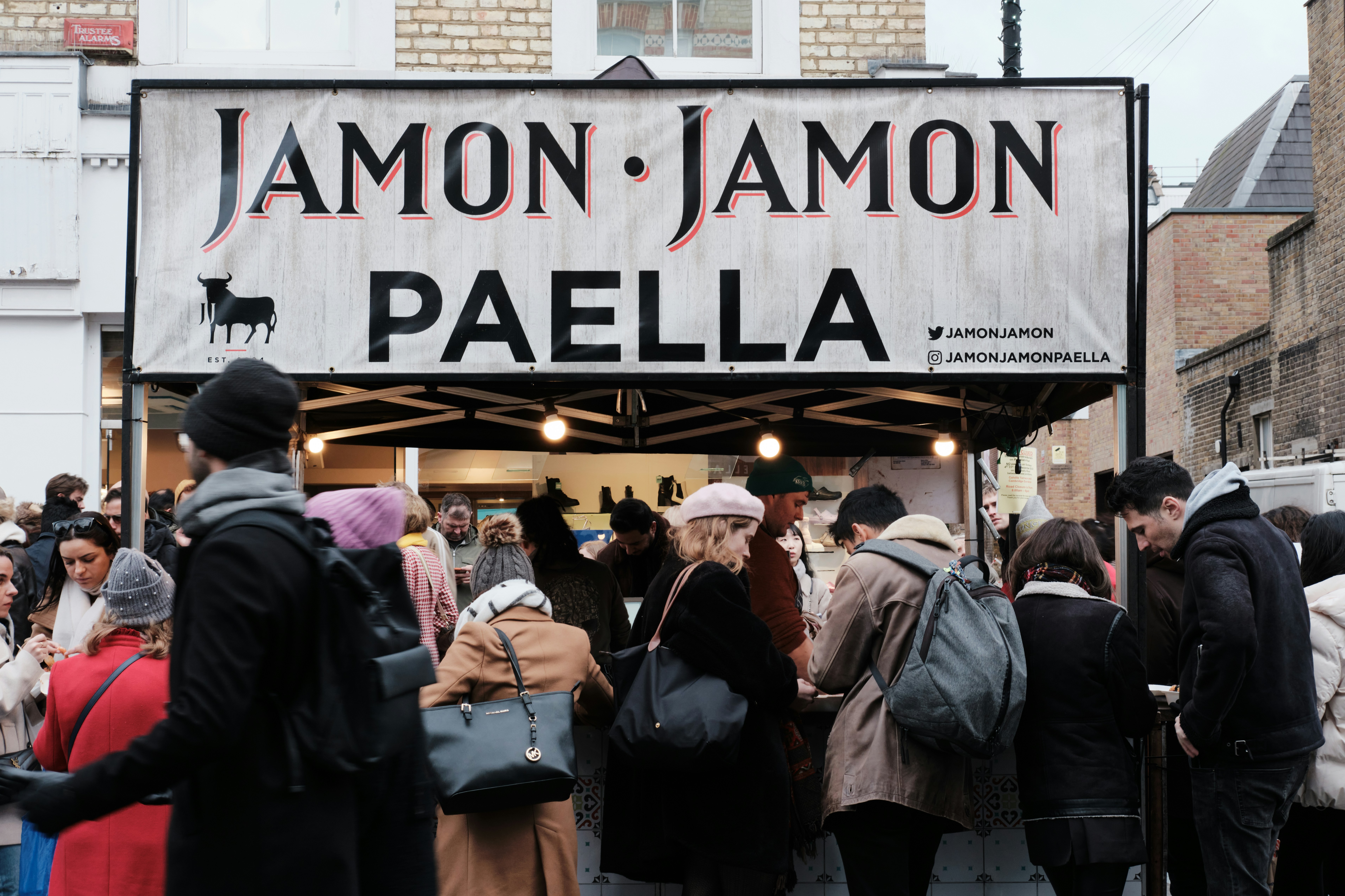 a group of people standing outside a building with a sign on it