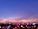A blurred cityscape at dusk with warm tones.