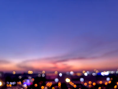 A blurred cityscape at dusk with warm tones.