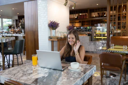 a person sitting at a table with a laptop