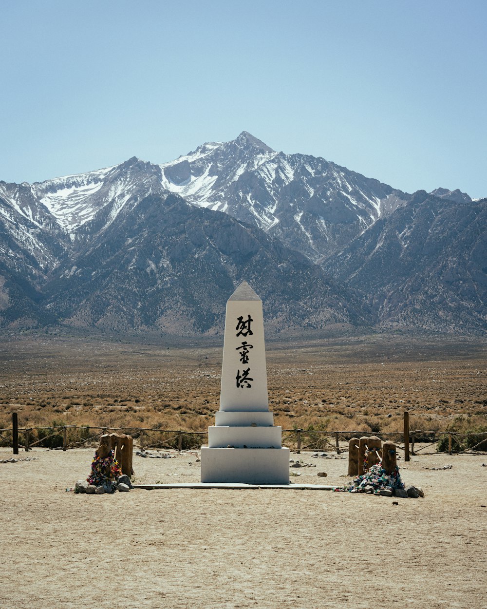 a white cylindrical object with a black text on it in front of a mountain range