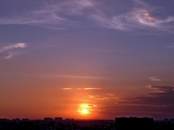 A vibrant sunset over London, showcasing the colors of yellow, blue, orange, and green.