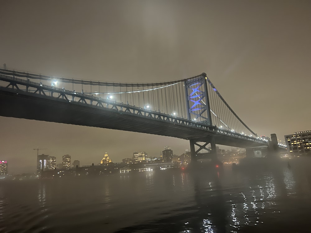 a bridge over water with a city in the background