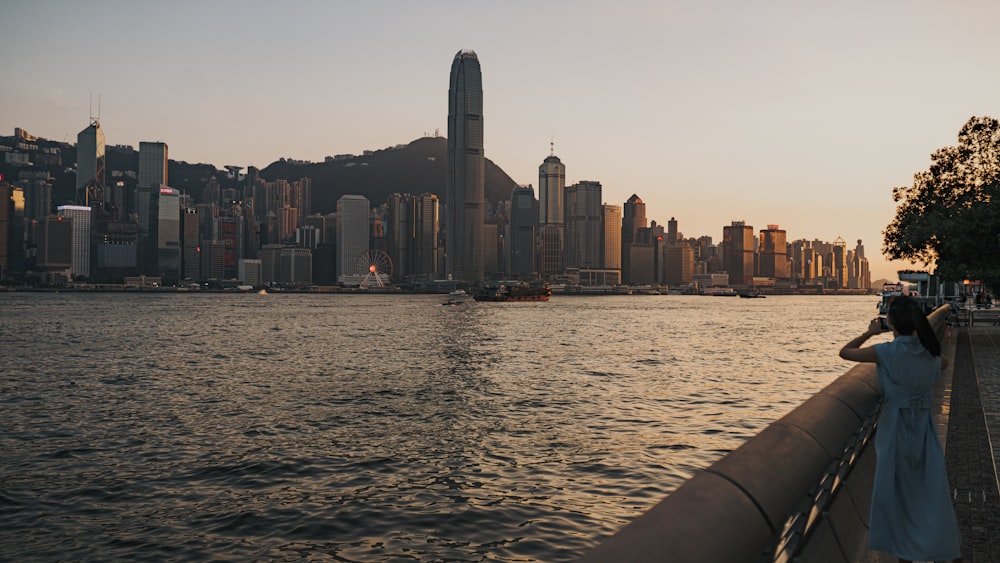 a person standing on a boat looking at a city skyline