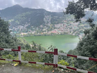 a red fence in front of a lake and a town