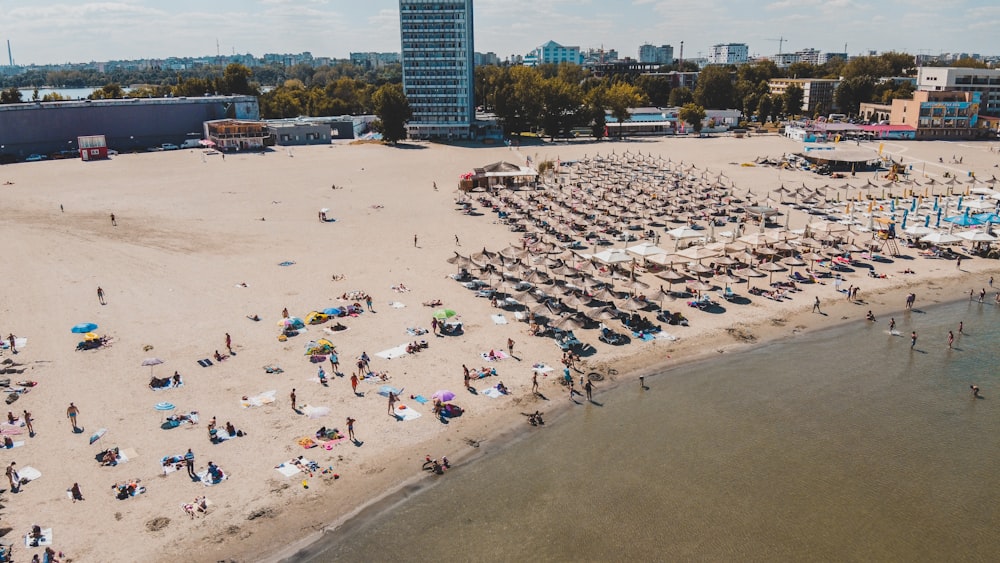 a crowded beach with boats and people