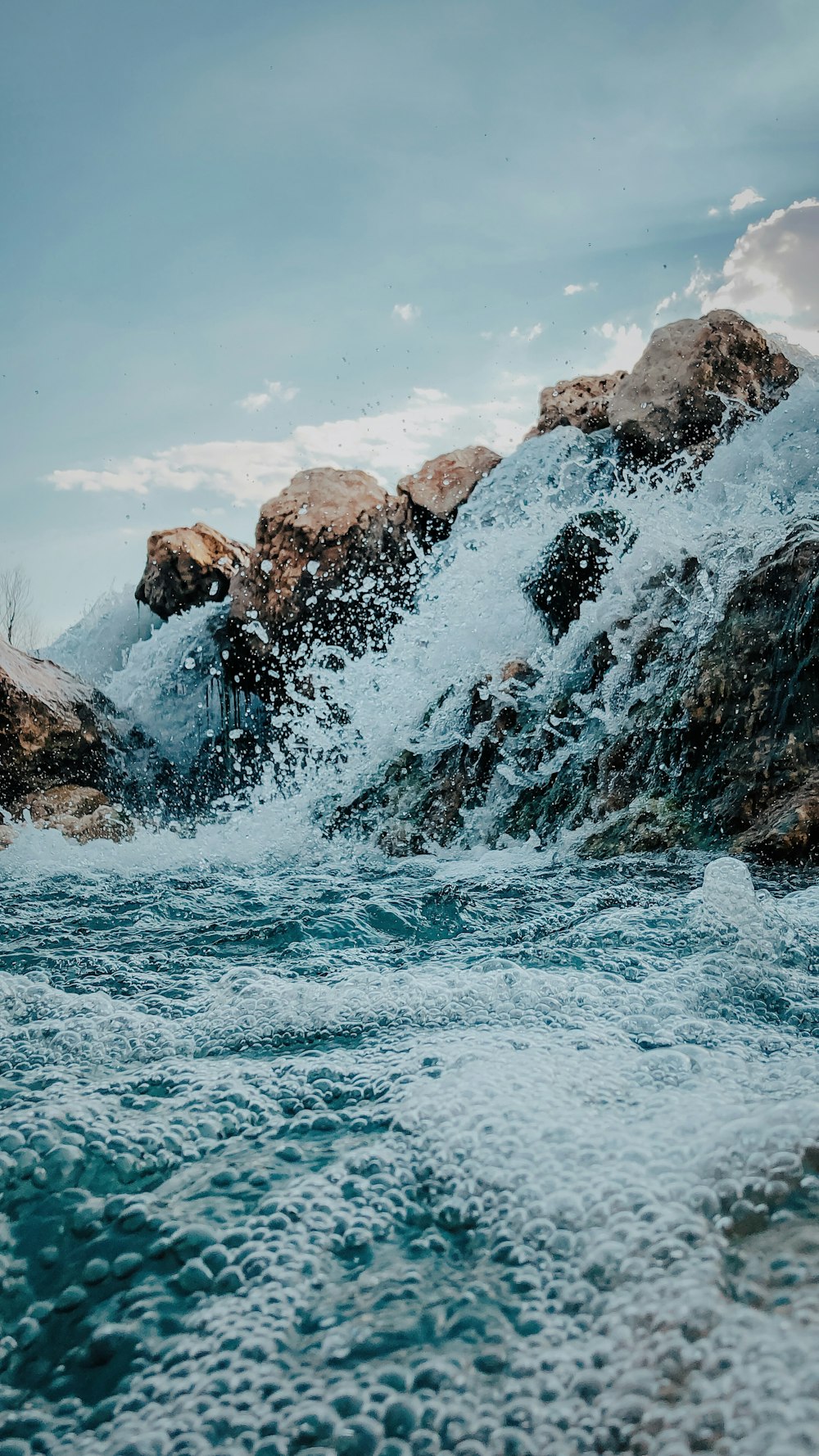 a body of water with rocks and a large waterfall