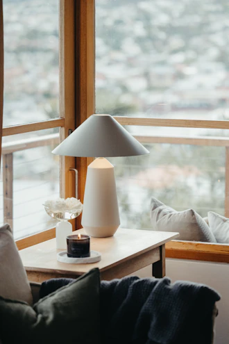 A cozy living room scene with smart home devices like a sleek lamp and a compact air purifier on a wooden side table.