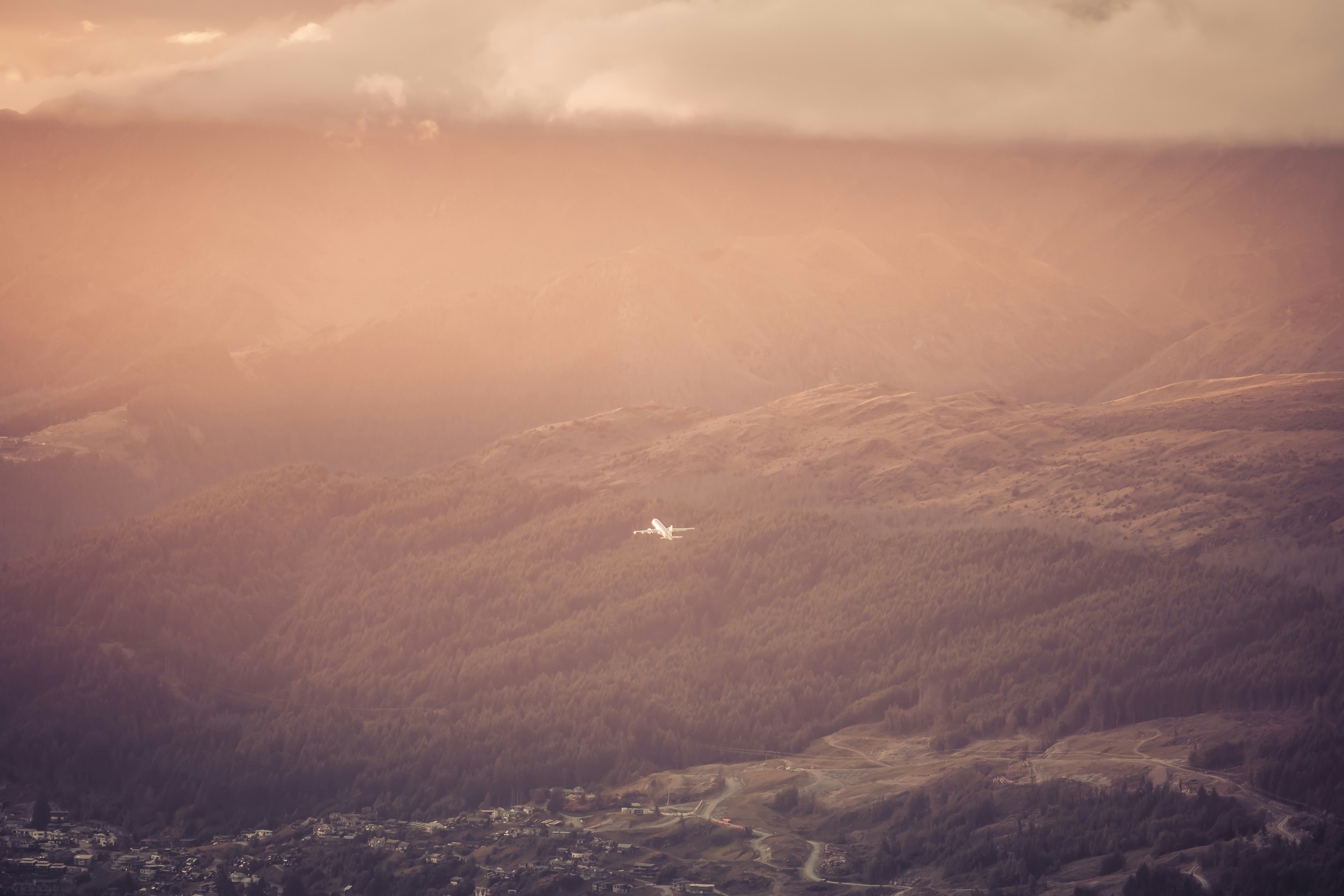 Avión sobrevolando paisaje montañoso al atardecer