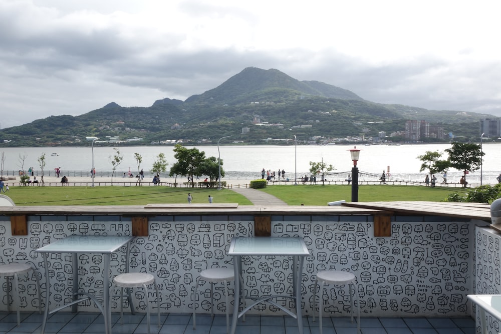 a patio with tables and chairs overlooking a body of water