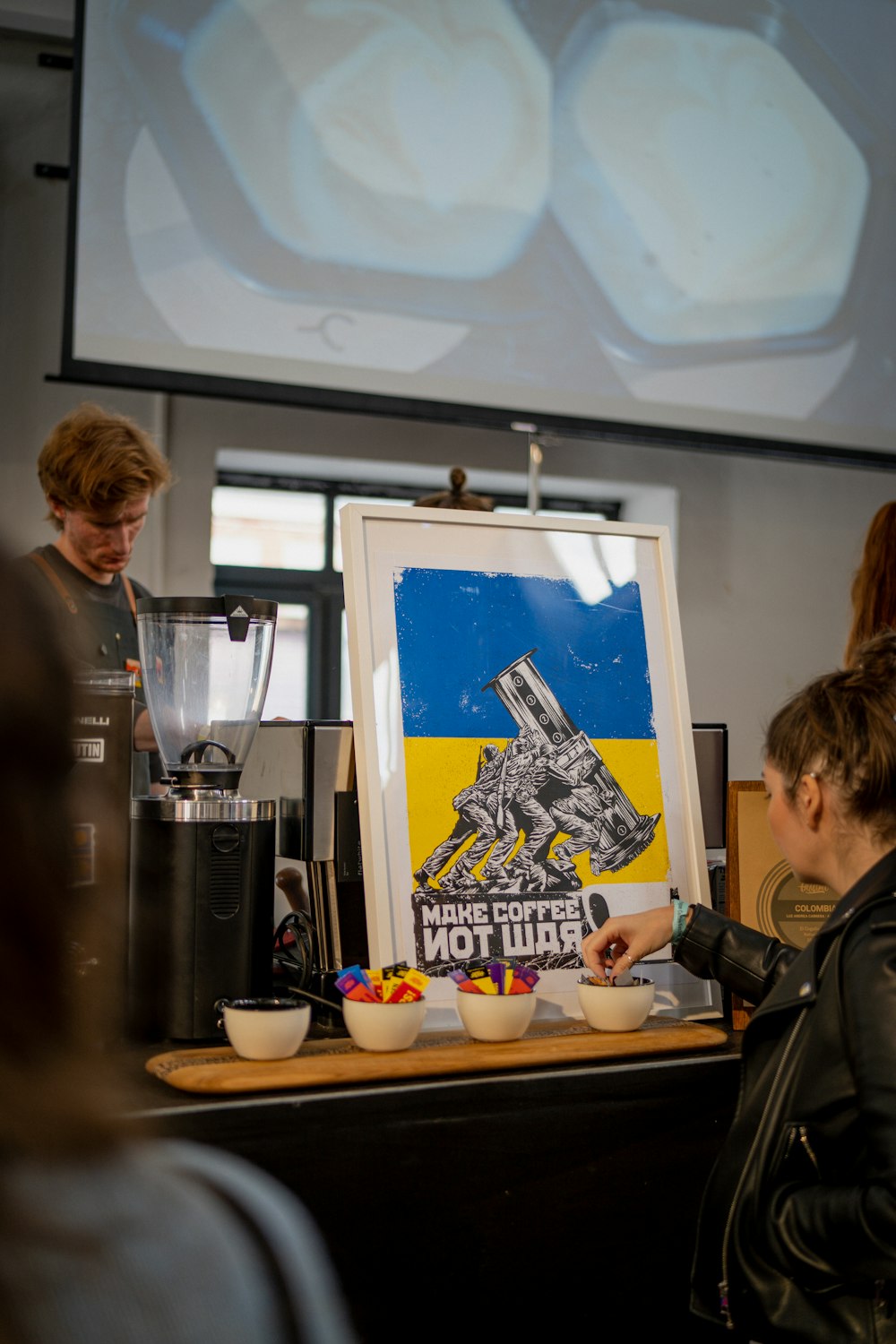 a person standing next to a table with a painting on it