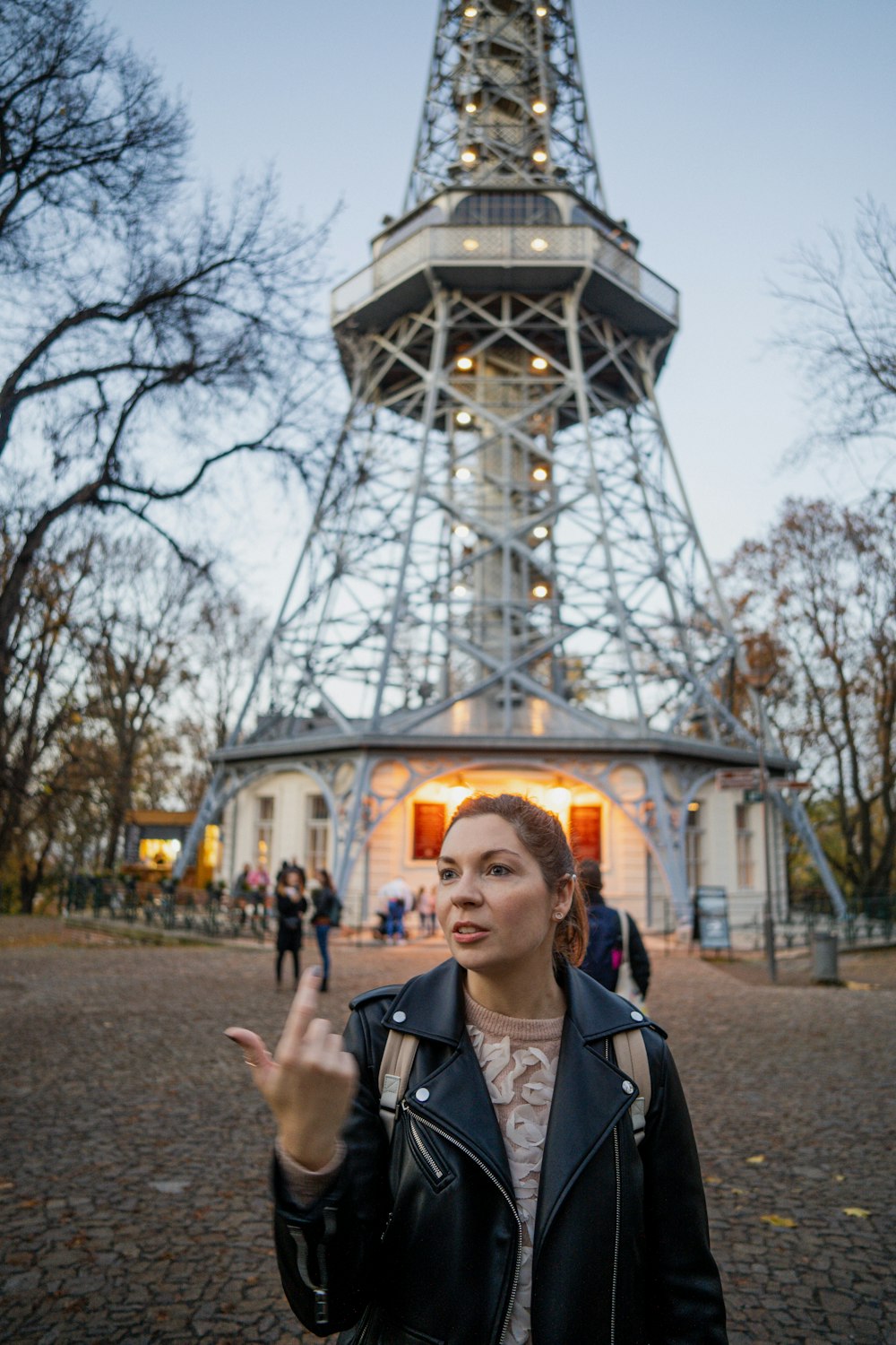 a person posing in front of a tall tower
