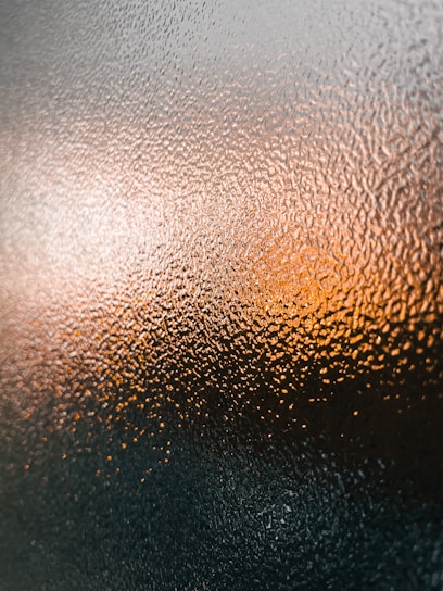 A frosted glass panel with soft gradient lighting reflecting a sleek iOS interface.