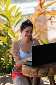 a woman sitting on a bench with a laptop