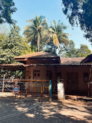 Private parking space shaded by Mediterranean trees near a bright vacation home.
