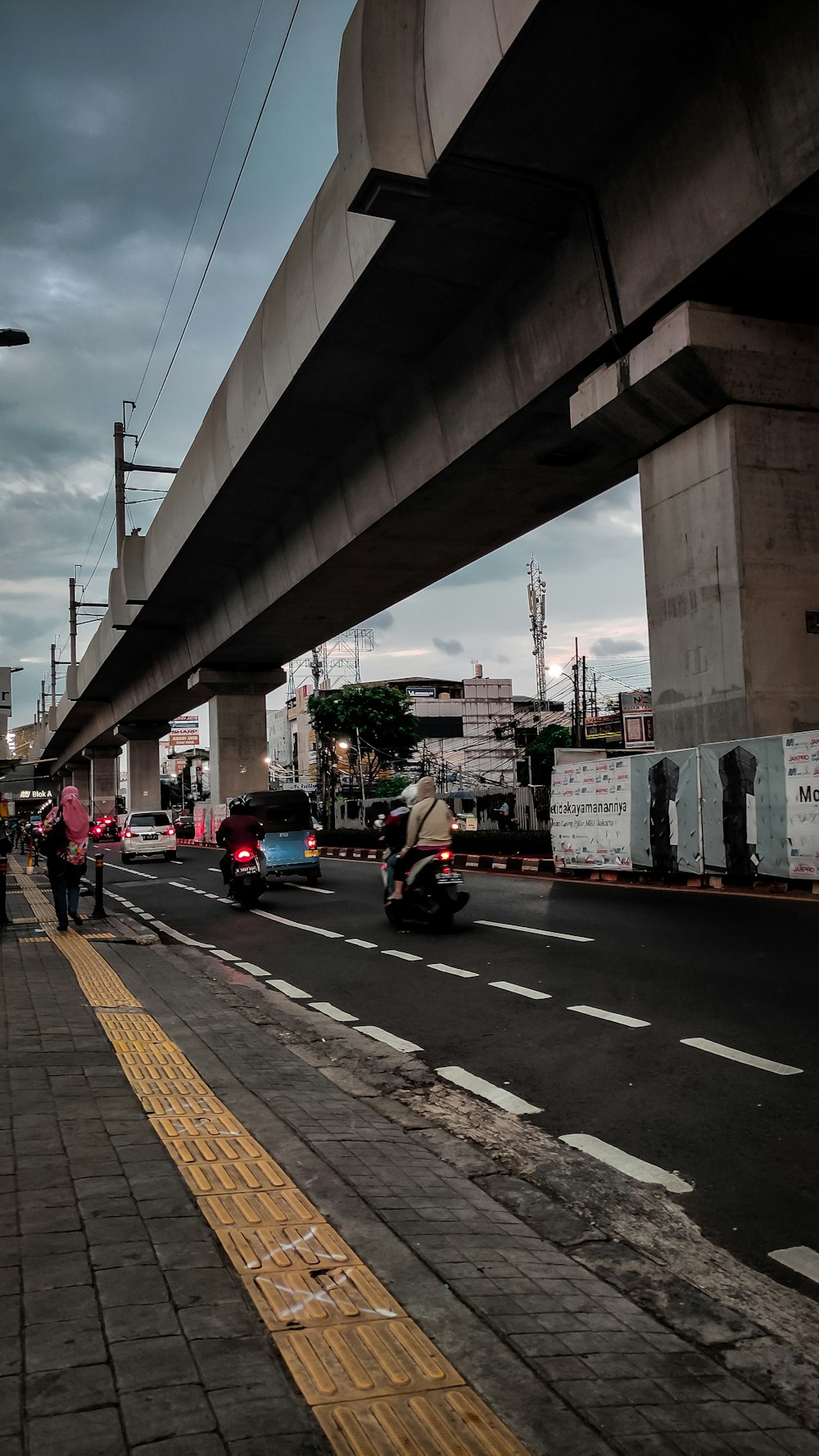 a person riding a motorcycle under a bridge