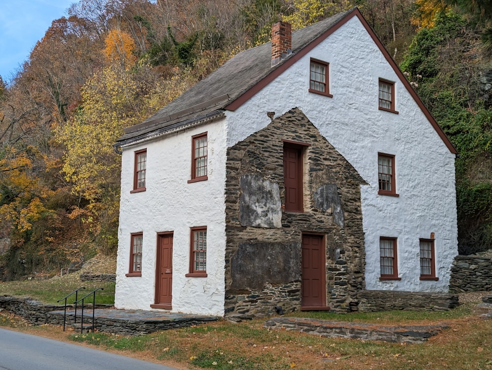 a white house with a stone wall