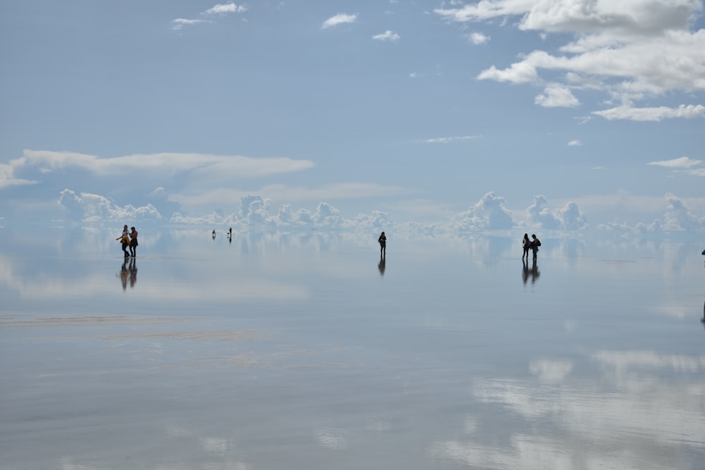 a group of people walking in the water