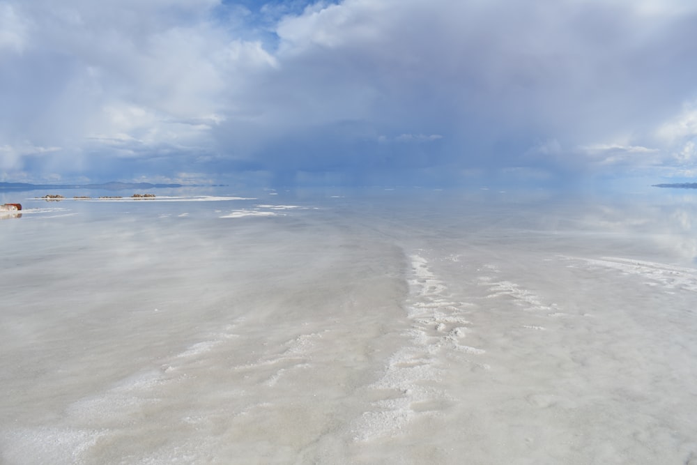 a body of water with clouds above it