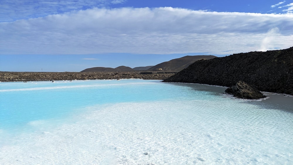 a body of water with hills in the background