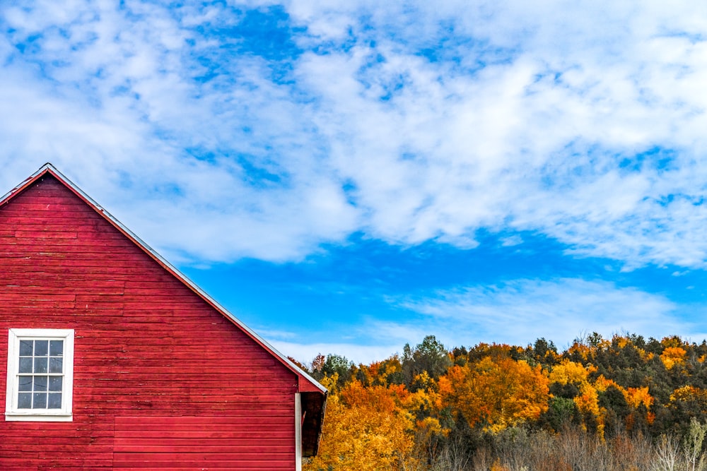 a red barn with trees in the back
