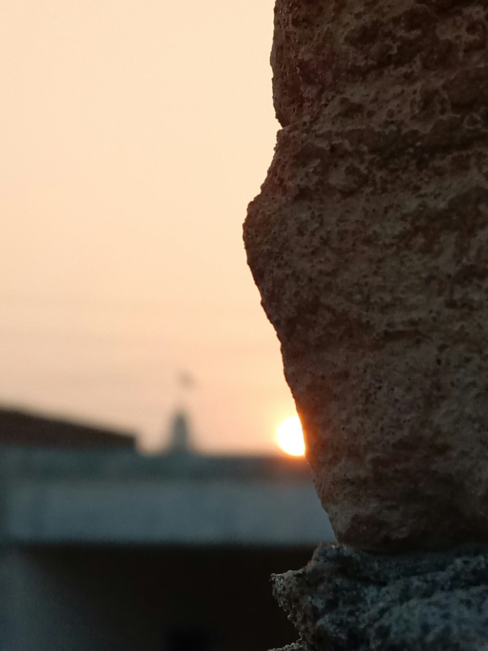 a rock with a sunset in the background