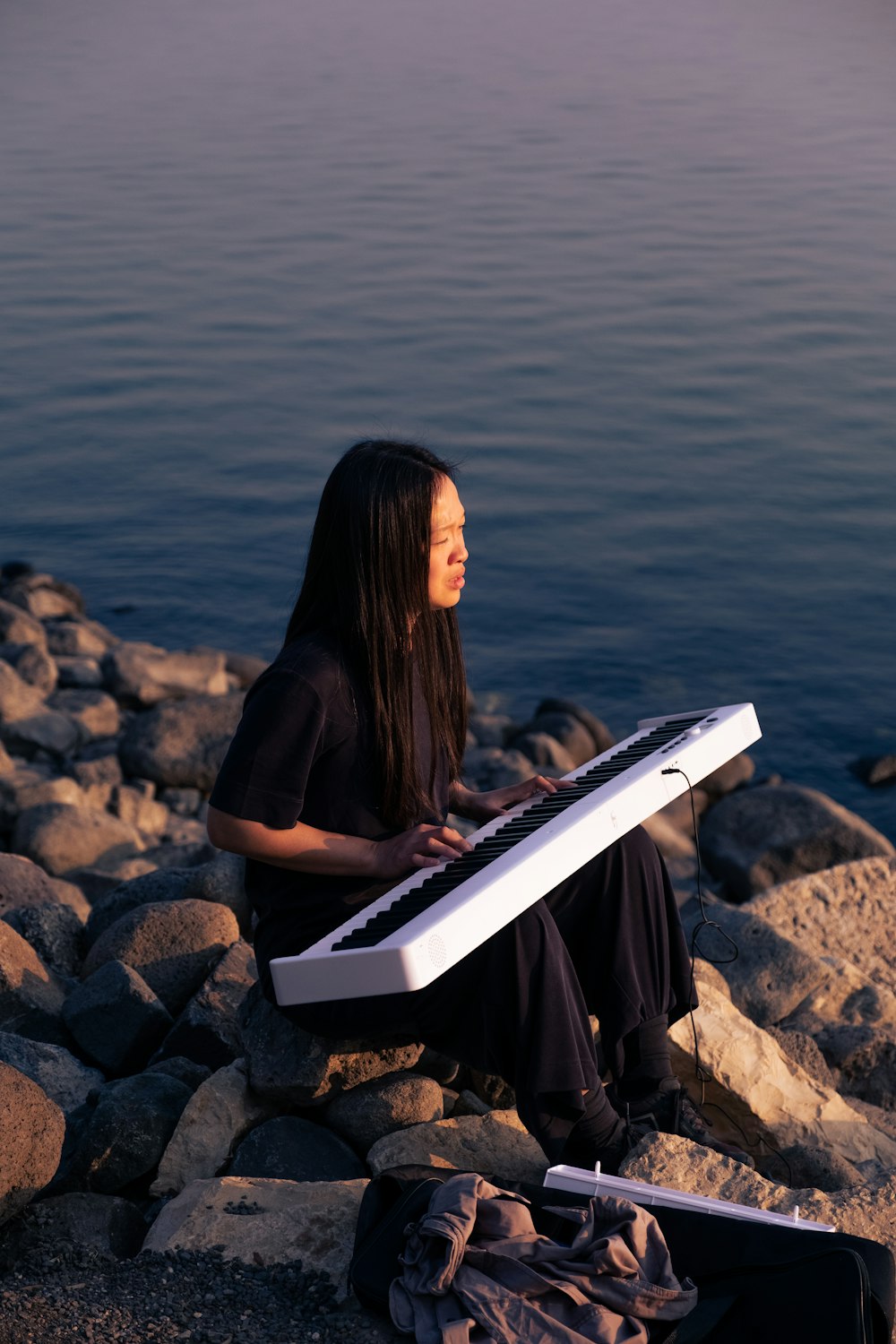 a person sitting on a rock reading a book