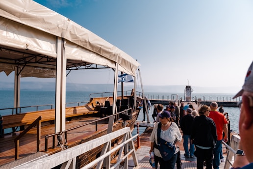 A group of volunteers preparing sailing gear on a dock with the Long Pass boat in the background.
