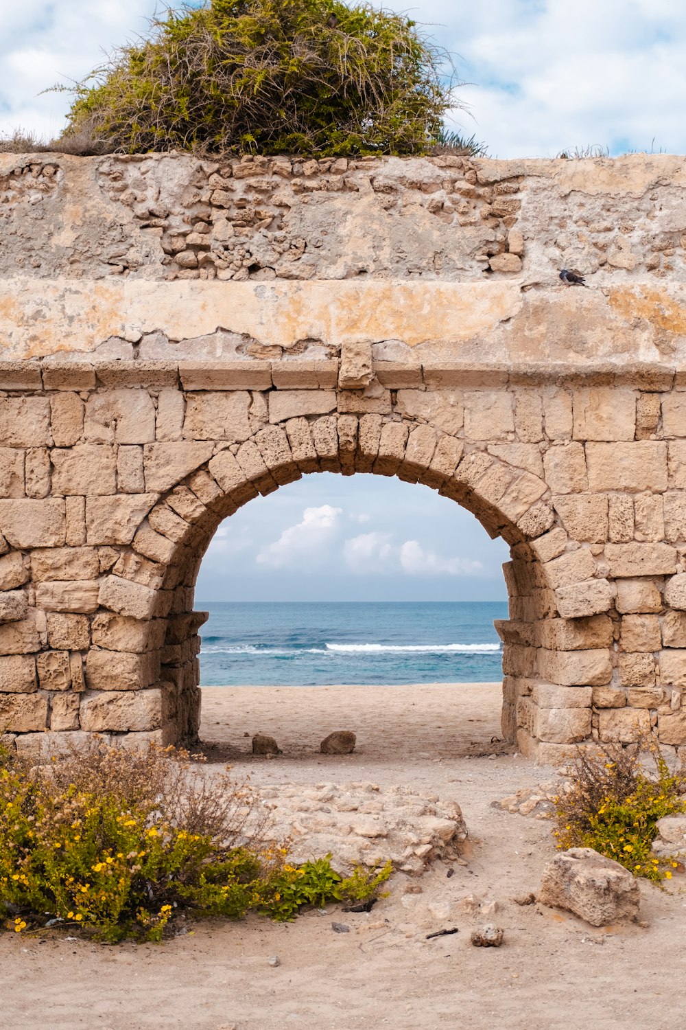 a stone archway over a beach