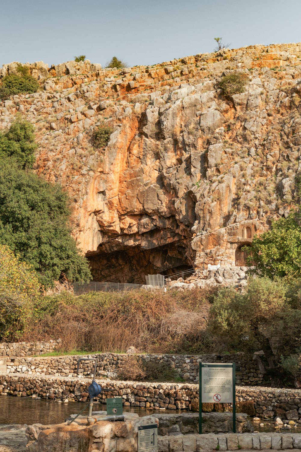 a large rock cliff with a sign